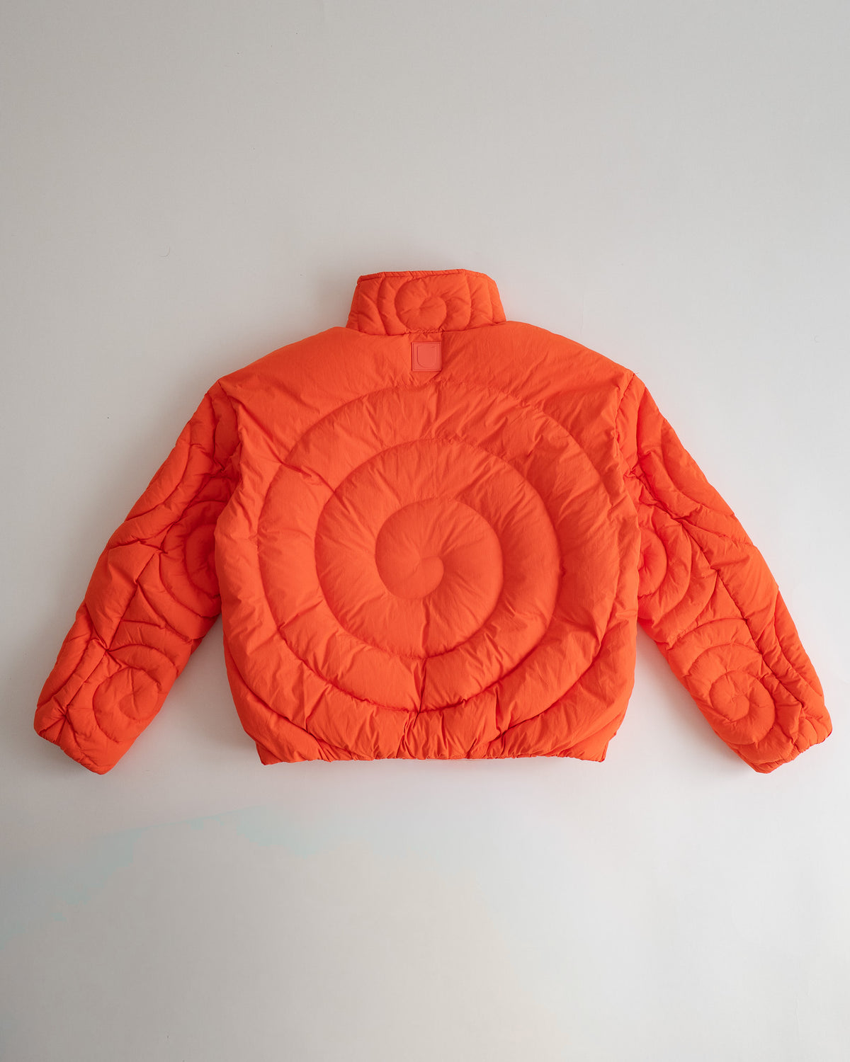 Jalebi Down Jacket, flat lay from the back, one big jalebi spiral quilted across the back