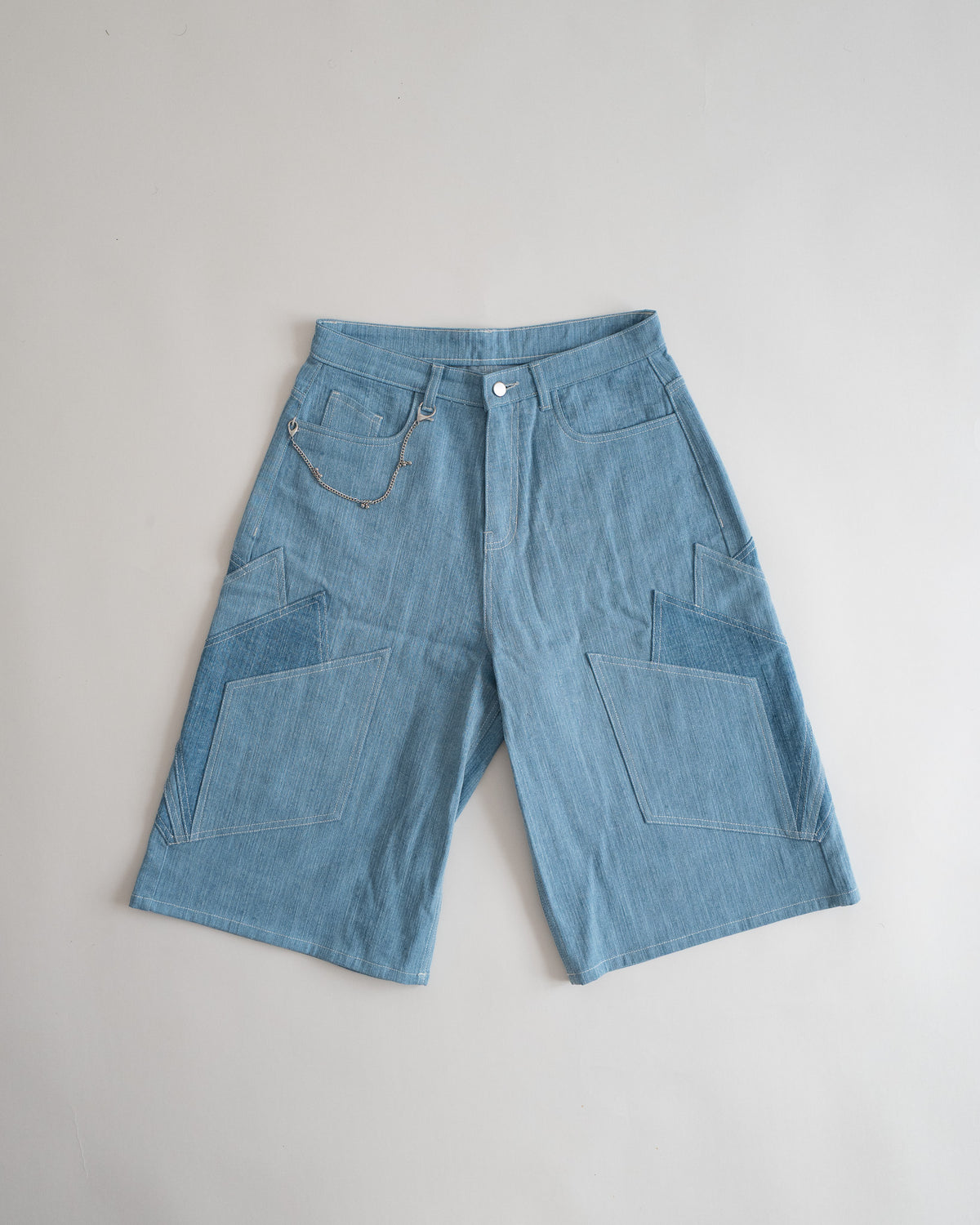 Khadi Katli Jorts in streaky khadi denim with a silver ghungroo chain, flat lay from the front