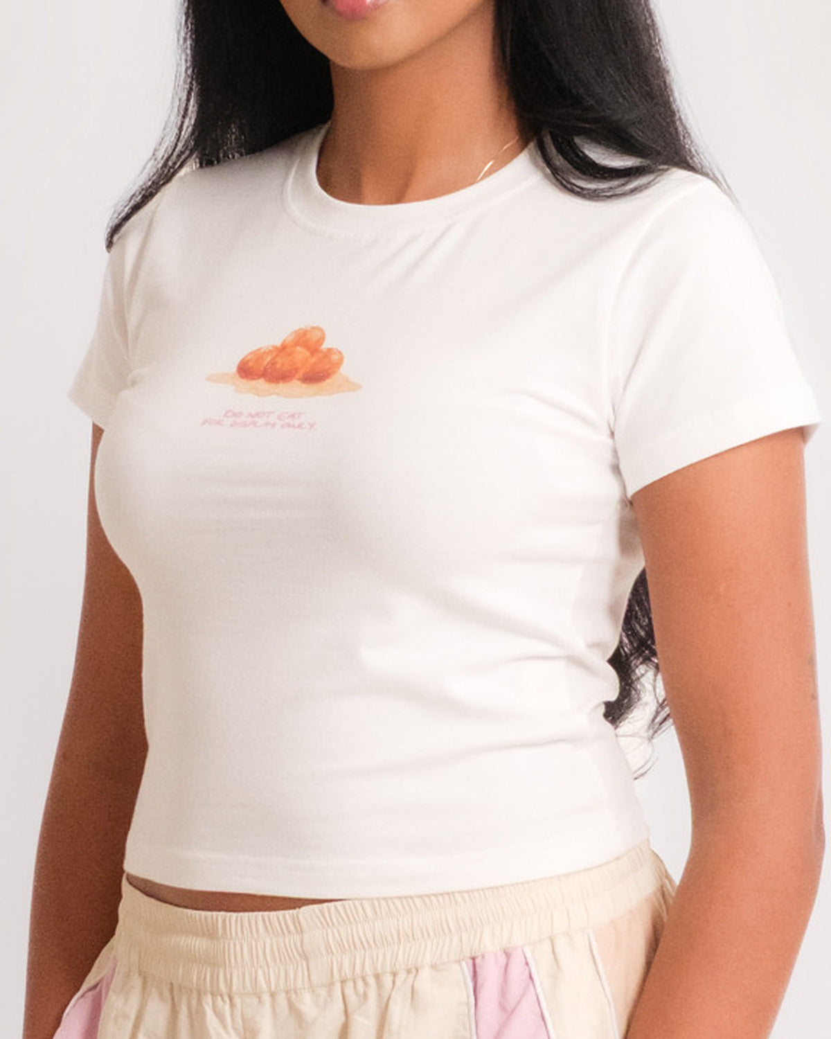 Woman in the Sweets Baby Tee in Gulab Jamun with the Sweets Track Pants in Rose Pink, hands in pockets #Color_Gulab Jamun