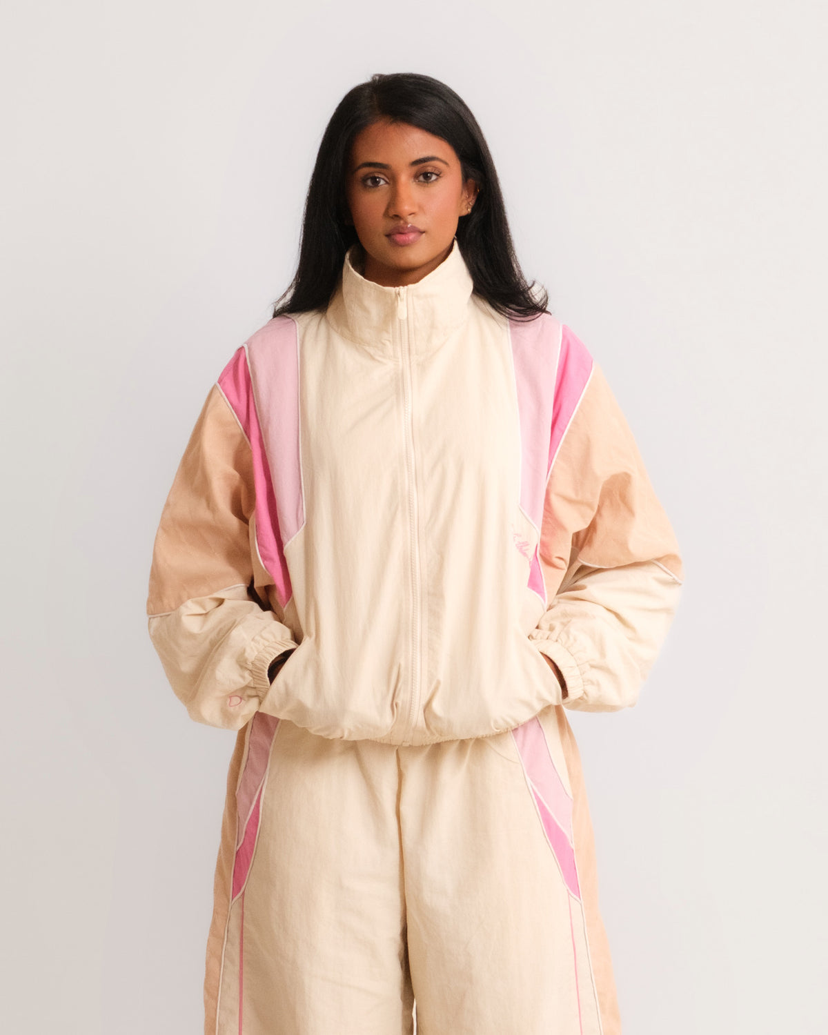 Woman wearing the Sweets Track Jacket in Rose Pink zipped up with the matching Sweets Track Pants, front view #Color_Rose Pink