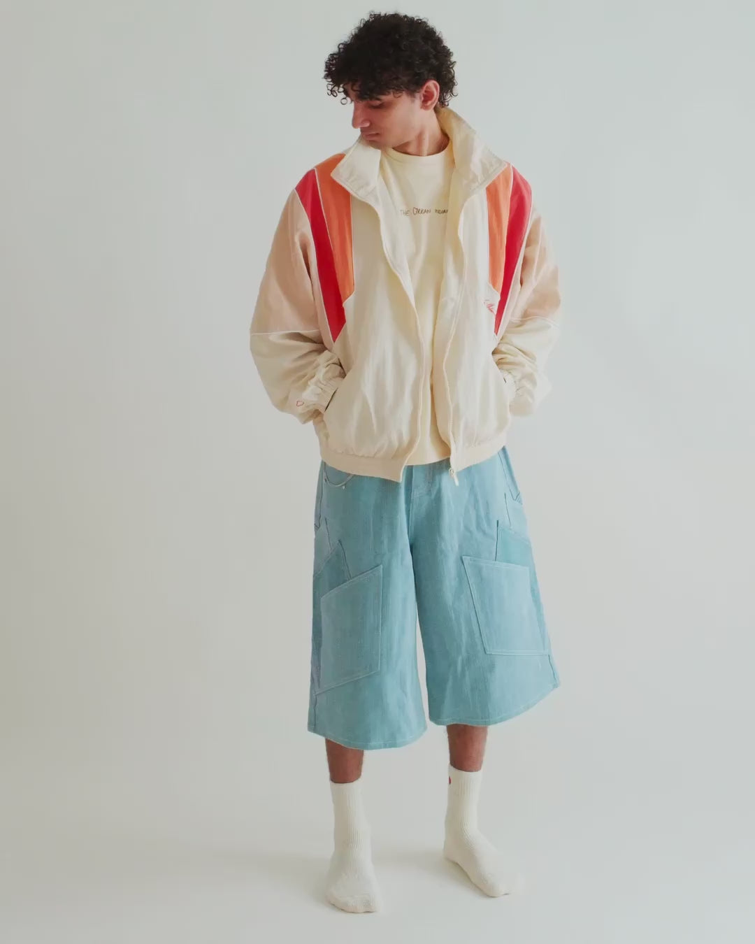 Video of a man in the Sweets Track Jacket in Saffron Orange with the Khadi Katli Jorts