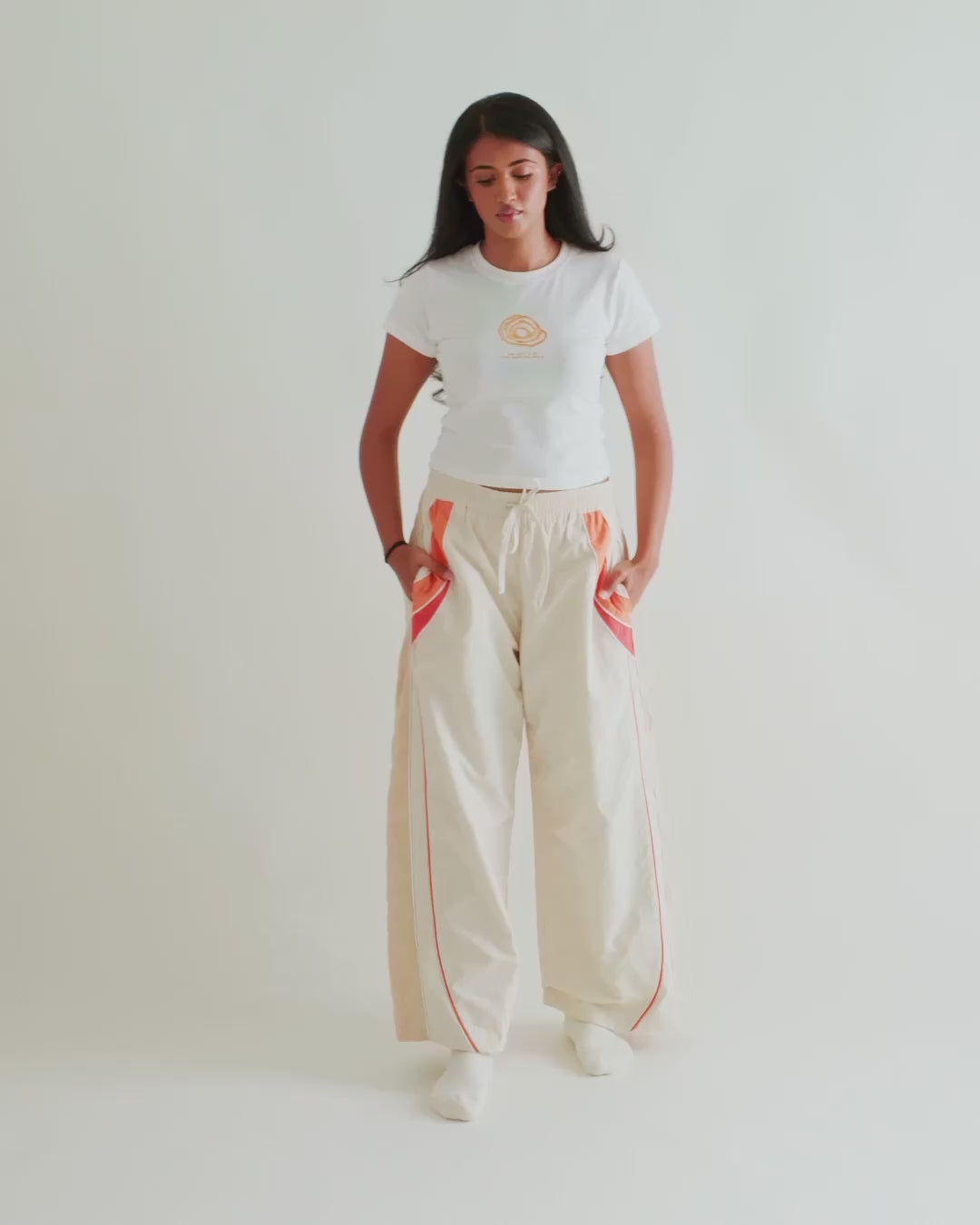 Video of a woman in the Sweets Baby Tee in Jalebi with the Sweets Track Pants in Saffron Orange