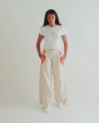 Video of a woman in the Sweets Baby Tee in Jalebi with the Sweets Track Pants in Saffron Orange