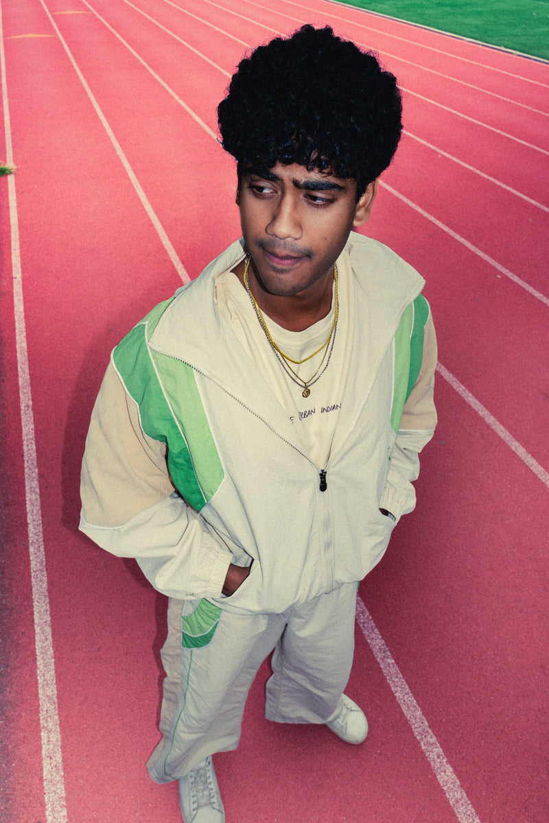 Man standing on a red running track in the Pista Green Sweets Track Set