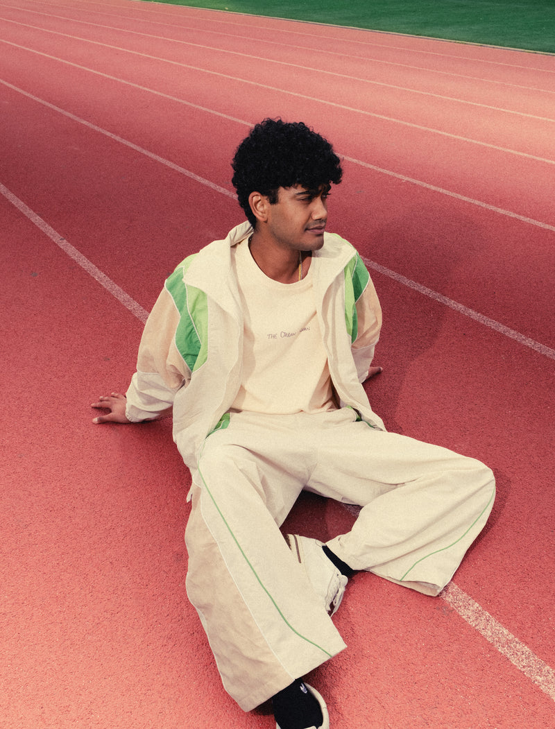 Man sitting back on a red running track in the Pista Green Sweets Track Set