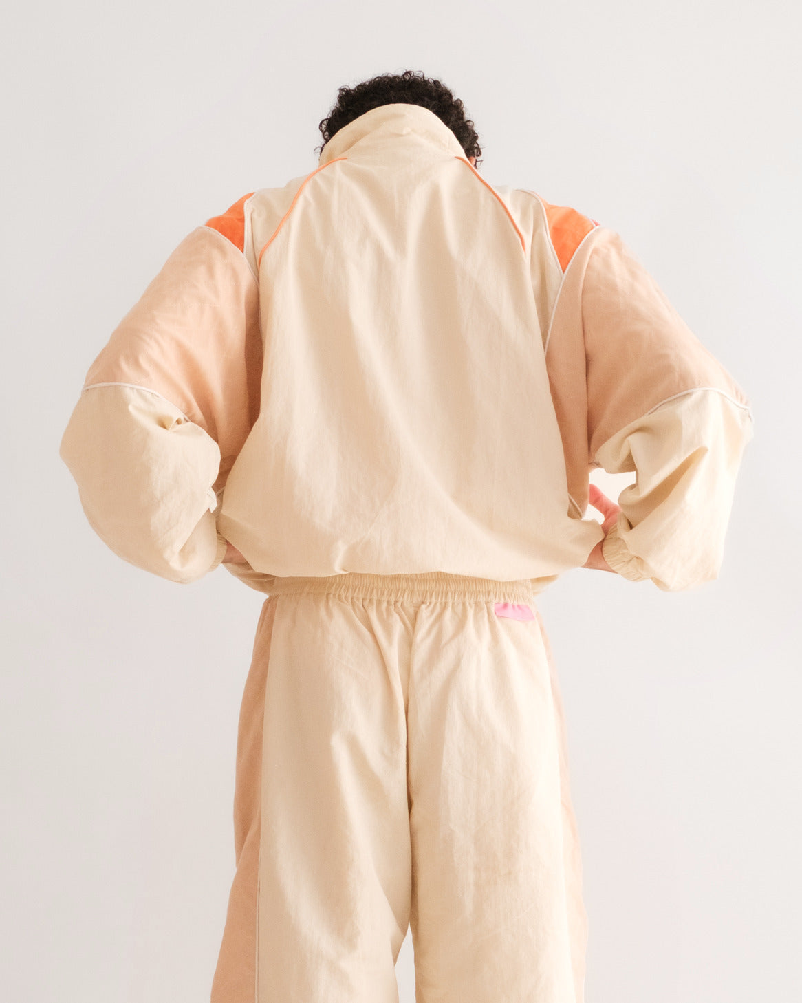 Back of the Sweets Track Jacket in Saffron Orange, worn with the Sweets Track Pants in Rose Pink #Color_Saffron Orange