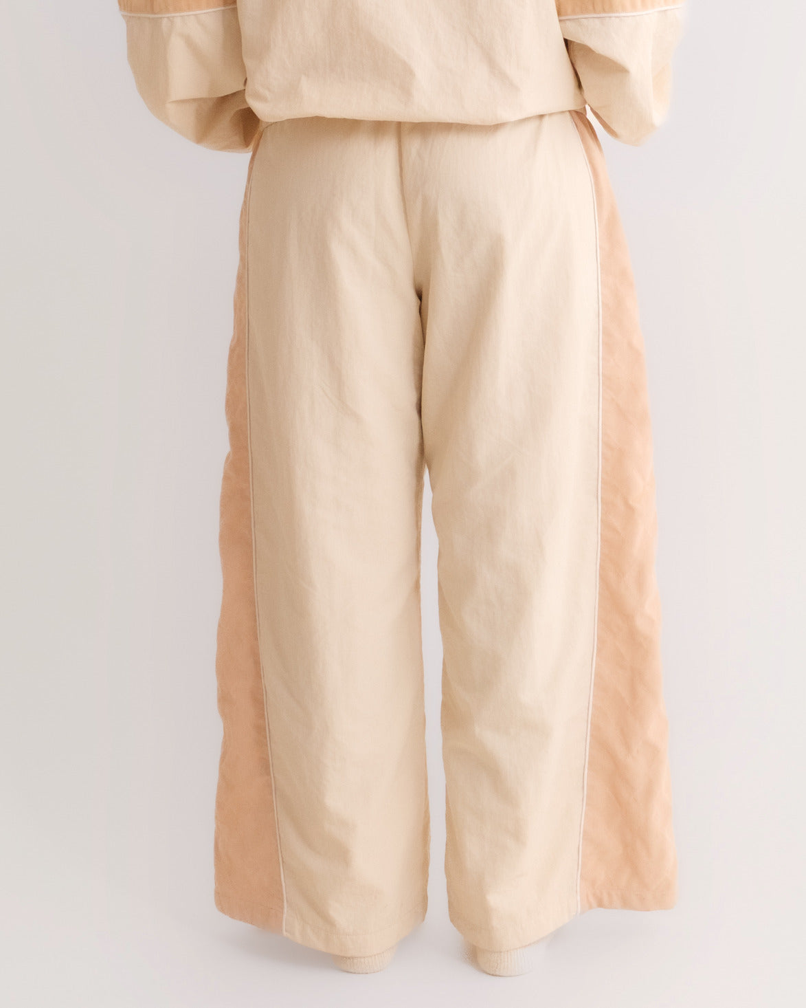 Woman from behind in the Pista Green Sweets Track Pants, wide barrel leg #Color_Pista Green