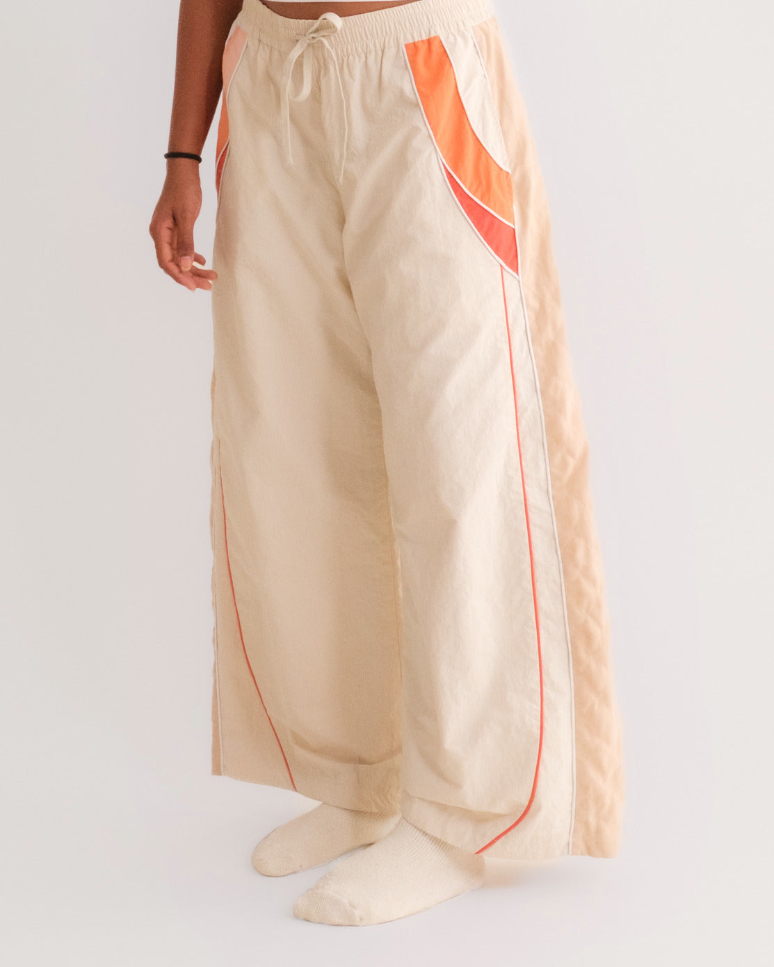 Woman in the Sweets Track Pants in Saffron Orange with the Sweets Baby Tee in Jalebi #Color_Saffron Orange