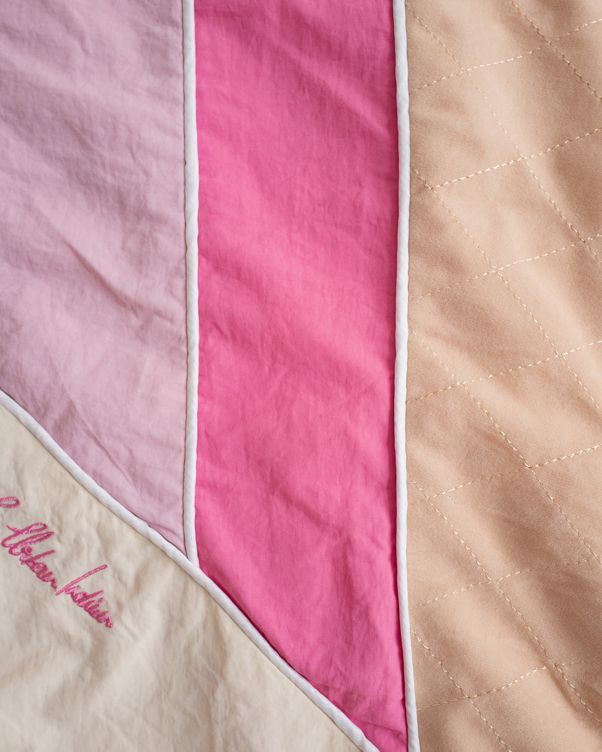 Close-up of the Rose Pink stripes, white piping and embroidered script on the Sweets Track Jacket #Color_Rose Pink