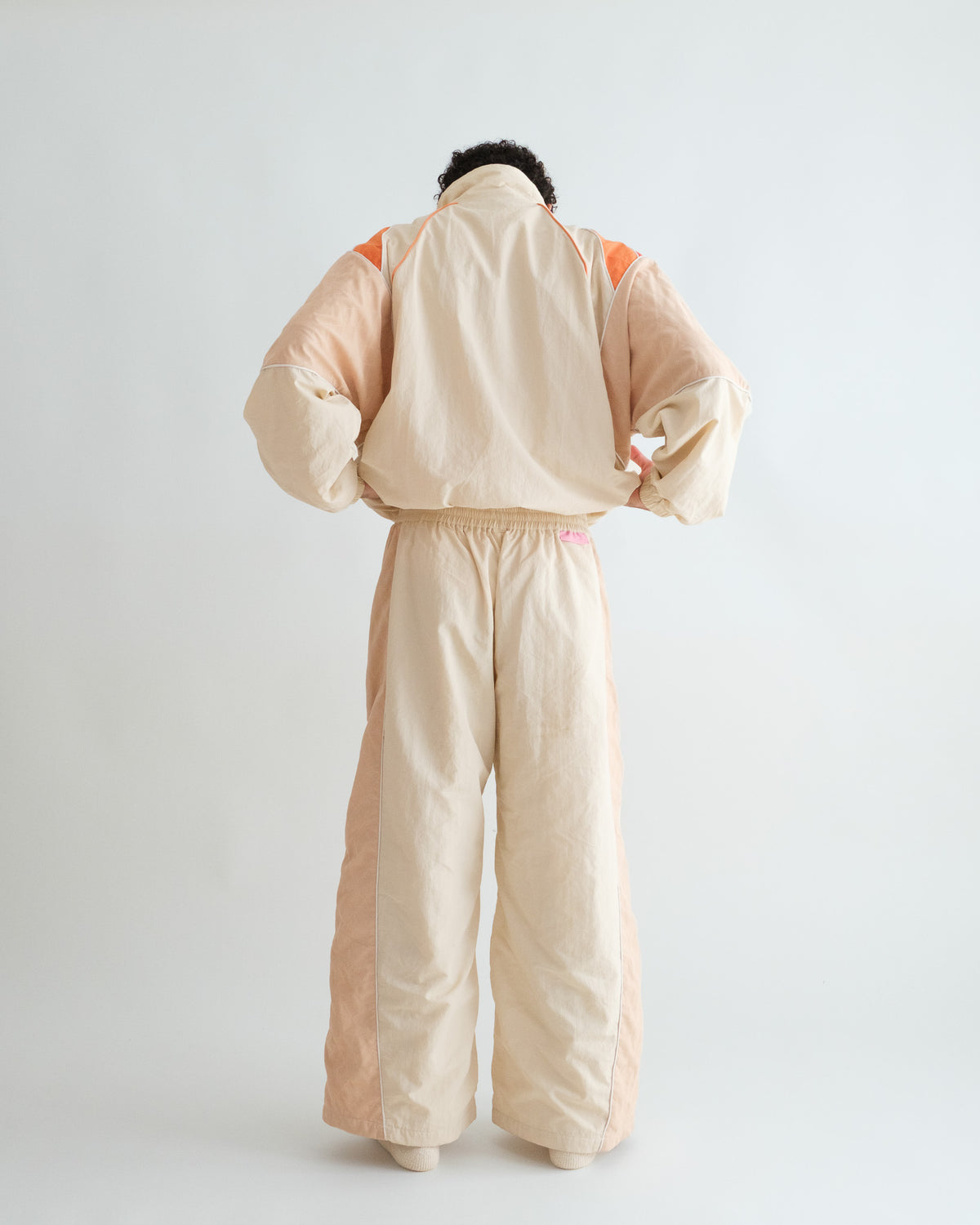 Back of the Sweets Track Jacket in Saffron Orange, worn with the Sweets Track Pants in Rose Pink #Color_Saffron Orange