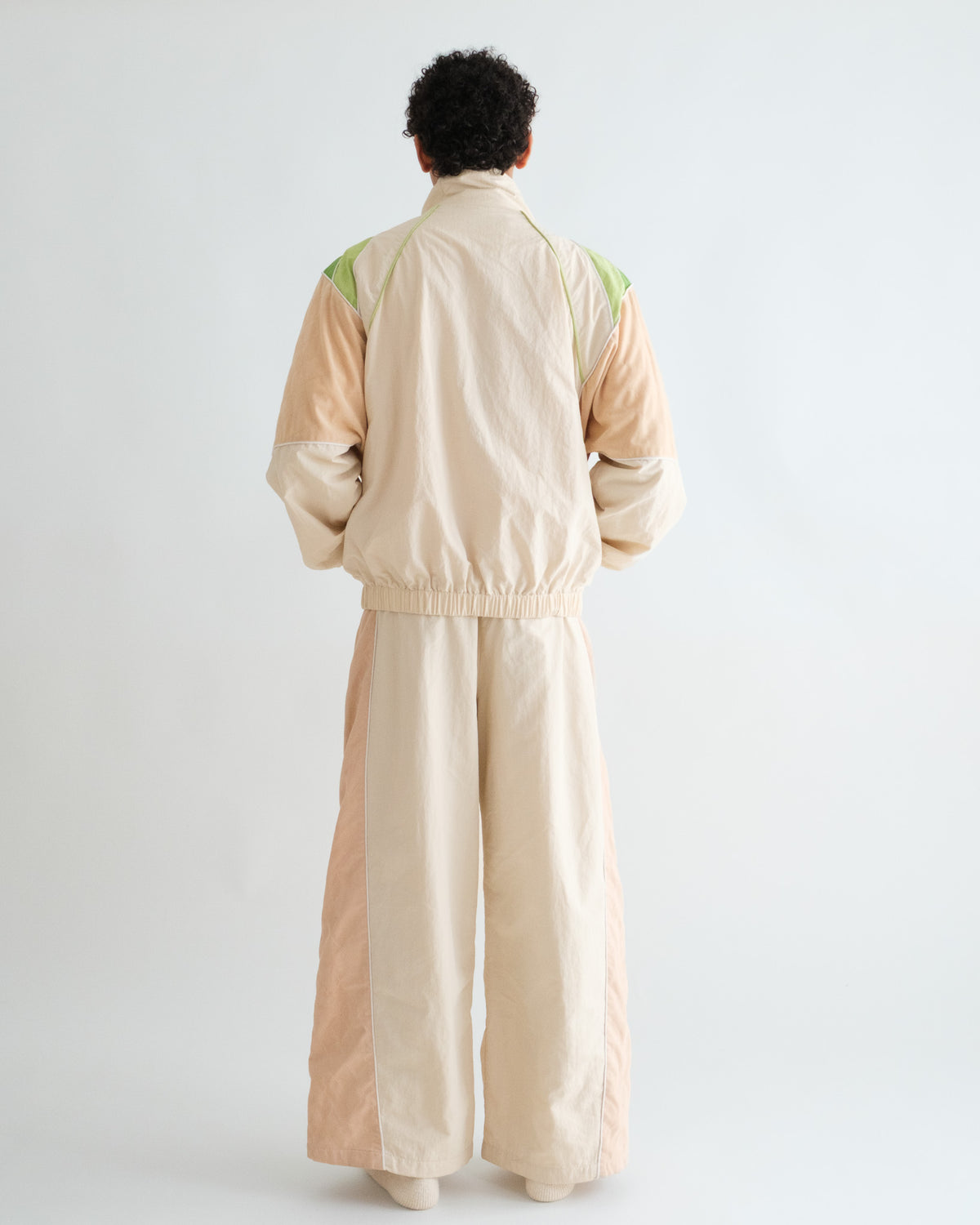 Man from behind in the Pista Green Sweets Track Jacket and Track Pants, green felt patches on the shoulders #Color_Pista Green